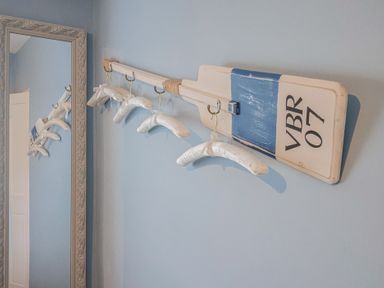 A coat rack with hangers and a mirror at Riverdance Cottage in Lyme Regis