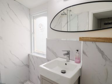 A bathroom with a sink and mirror at Riverdance Cottage in Lyme Regis