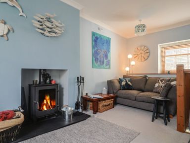 A living room with a sofa and fireplace at Riverdance Cottage in Lyme Regis