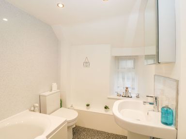 A bathroom with a bathtub toilet and sink at Barton Cottage in Bourton-On-The-Water
