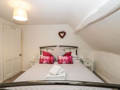 A bedroom with a double bed and bedside tables with lamps at Barton Cottage in Bourton-On-The-Water