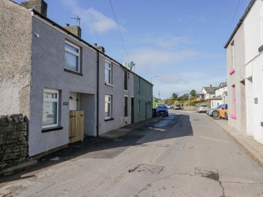 A street view with parked cars and rows of houses at Crag View Cottage in Stainton with Adgarley near Dalton-In-Furness