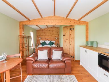 A living room with a sofa and dining area at Lodge 1 in York