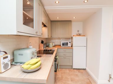 A kitchen with countertop appliances including a microwave kettle and toaster with bananas on a plate at Braeside in Fylingthorpe