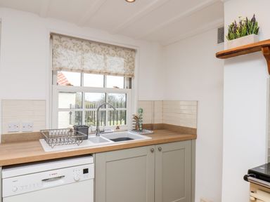 A kitchen corner with a double sink a faucet a dish rack and dishwasher under the counter at Braeside in Fylingthorpe