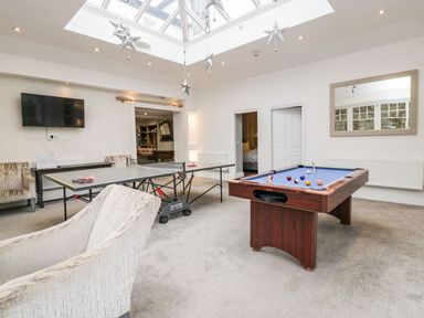 A game room with a pool table and ping pong table under a skylight at Valley View in Dalton-In-Furness