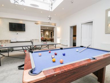 A game room with a pool table and ping pong table and a wall-mounted TV at Valley View in Dalton-In-Furness