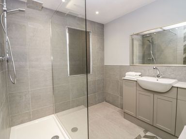 A bathroom with a walk-in shower and a sink with cabinet at Valley View in Dalton-In-Furness