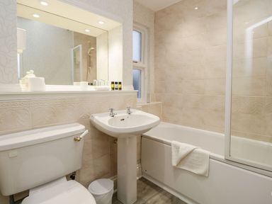 A bathroom with a toilet sink bathtub and large mirror at Valley View in Dalton-In-Furness