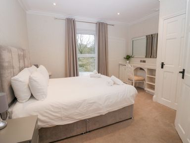 A bedroom with a bed bedside table desk chair and mirror at Valley View in Dalton-In-Furness