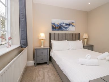 A bedroom with a double bed two bedside tables lamps and a window at Valley View in Dalton-In-Furness
