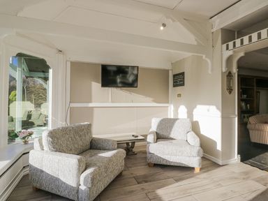 A snug with armchairs and a television at Valley View in Dalton-In-Furness