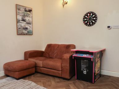 A game room with a couch and arcade machine at Bridlington Bay House in Bridlington