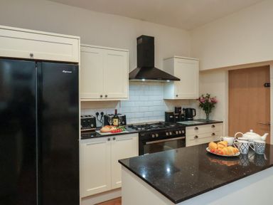 A kitchen with a refrigerator, stove, and sink at Bridlington Bay House in Bridlington