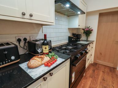 A kitchen with a countertop featuring bread, wine, and tomatoes at Bridlington Bay House in Bridlington