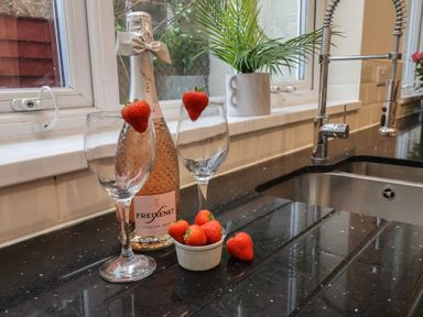 A kitchen featuring champagne flutes, a wine bottle, and strawberries at Bridlington Bay House, Bridlington