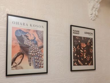 Framed prints on a wall featuring peacocks and flower market at Bridlington Bay House in Bridlington