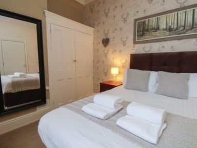 A bedroom with a bed and wardrobe at Bridlington Bay House in Bridlington