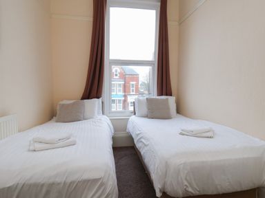 A bedroom with two beds and a window at Bridlington Bay House in Bridlington