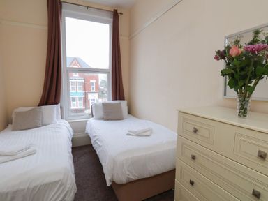 A bedroom with two beds and a dresser at Bridlington Bay House in Bridlington