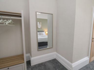 A bedroom with a mirror and closet at Bridlington Bay House in Bridlington