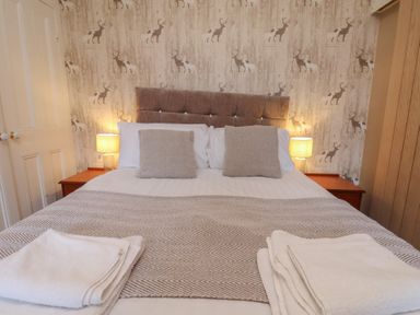 A bedroom with a bed and curtains at Bridlington Bay House in Bridlington
