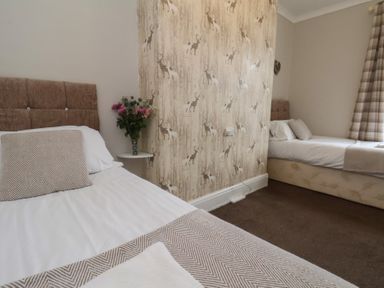 A bedroom with two beds and a flower vase at Bridlington Bay House in Bridlington