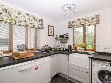 A kitchen with a toaster sink washing machine and dishwasher at Little Stables Cottage Spetisbury
