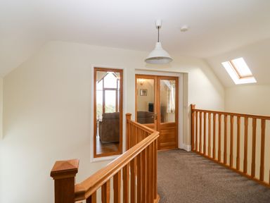A hallway with wooden banisters carpeted floor and skylight at Ballycahane in Castletownshend County Cork