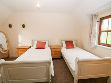 A bedroom with two single beds and wooden bedside tables at Ballycahane in Castletownshend County Cork