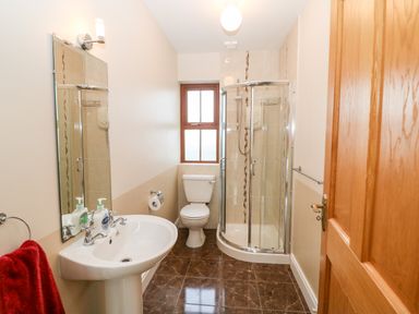 A bathroom with a sink mirror toilet and corner shower at Ballycahane in Castletownshend County Cork