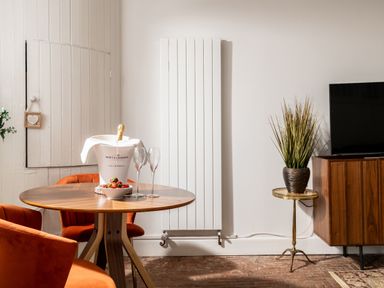 A living room with a table and champagne bucket at Stable in Blandford Forum