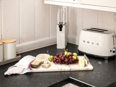 A kitchen with grapes and cheese on a cutting board at Stable in Blandford Forum