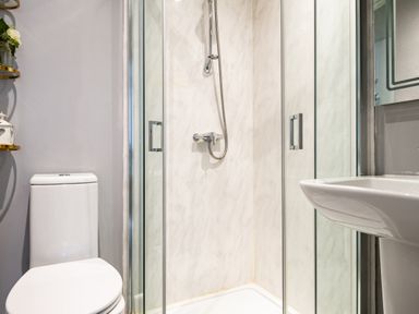 A bathroom with a shower, toilet, and sink at Stable in Blandford Forum