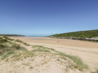 A beach with sand and ocean in the background at Newquay Tamarisk Lodge on the Gannel Newquay