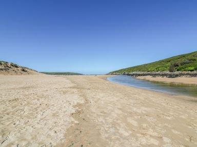 A beach with a river and hills at Newquay Tamarisk Lodge on the Gannel Newquay