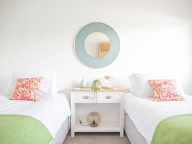A bedroom with two beds and a mirror at Newquay Tamarisk Lodge on the Gannel Newquay