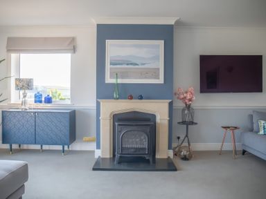 A living room with a fireplace and TV at Newquay Tamarisk Lodge on the Gannel in Newquay