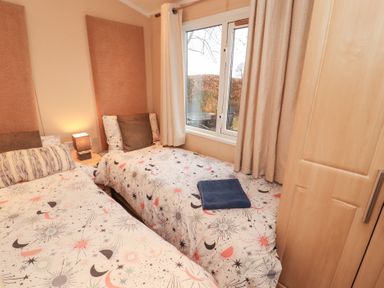 A bedroom with two beds and a window at Rosie's Zen Den in High Hesket near Armathwaite