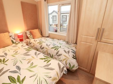 A bedroom with two beds and a window at Rosie's Zen Den in High Hesket near Armathwaite