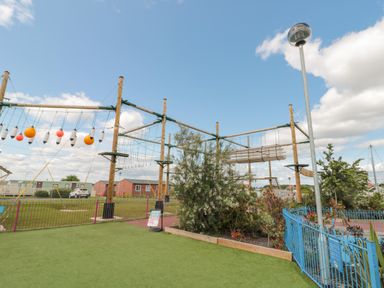 An outdoor ropes course with wooden platforms and hanging obstacles at Rowan Court 2 in Cayton
