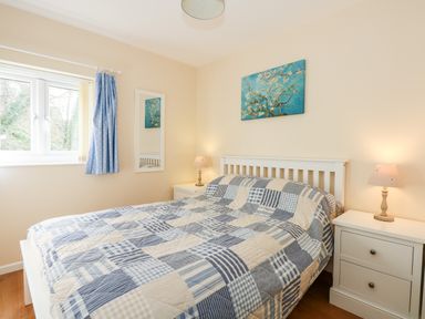A bedroom with a bed and two bedside tables with lamps at 1 The Dell in Mundesley