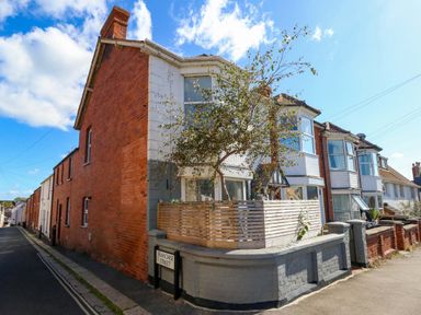 A house with a tree and a fence on Franchose Street at The Old Post Office in Weymouth