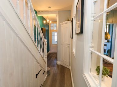 A hallway with a staircase and door at The Old Post Office in Weymouth