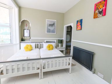 A bedroom with beds and a radiator at The Old Post Office in Weymouth