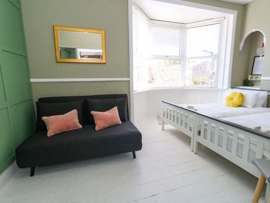 A bedroom with a sofa and a bed at The Old Post Office in Weymouth