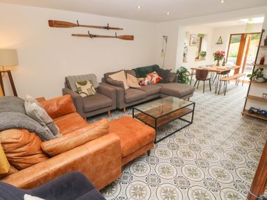 A living room with sofas a glass coffee table patterned floor and a dining area at Rudbaxton Water Rudbaxton near Haverfordwest