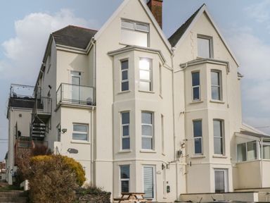 A large white residential building with multiple windows and a balcony at 5 Seymour Villas in Woolacombe