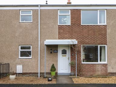 Front exterior of a two-story house with a white door and windows at Willows in Corbridge
