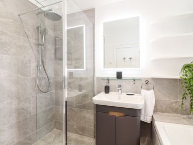 A bathroom with a walk-in shower sink with a mirror and bath at Trevilges Cottage Trewennack near Helston